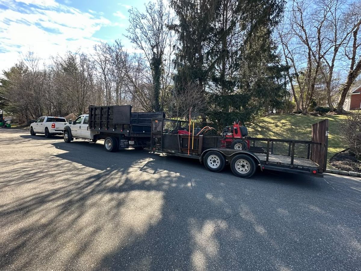 Work truck and dump trailer staged for a commercial grounds visit