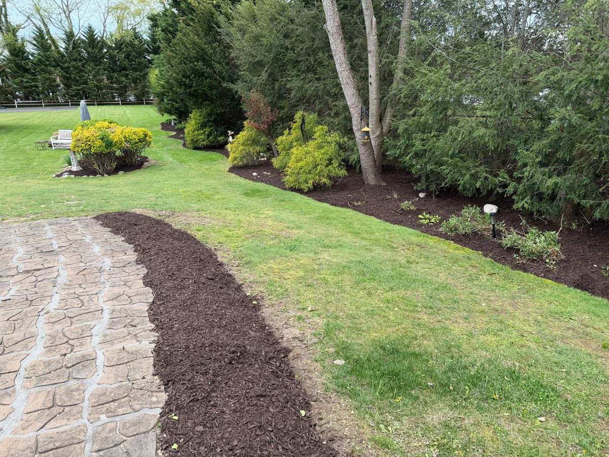 Newly mulched planting bed running alongside a stone walkway