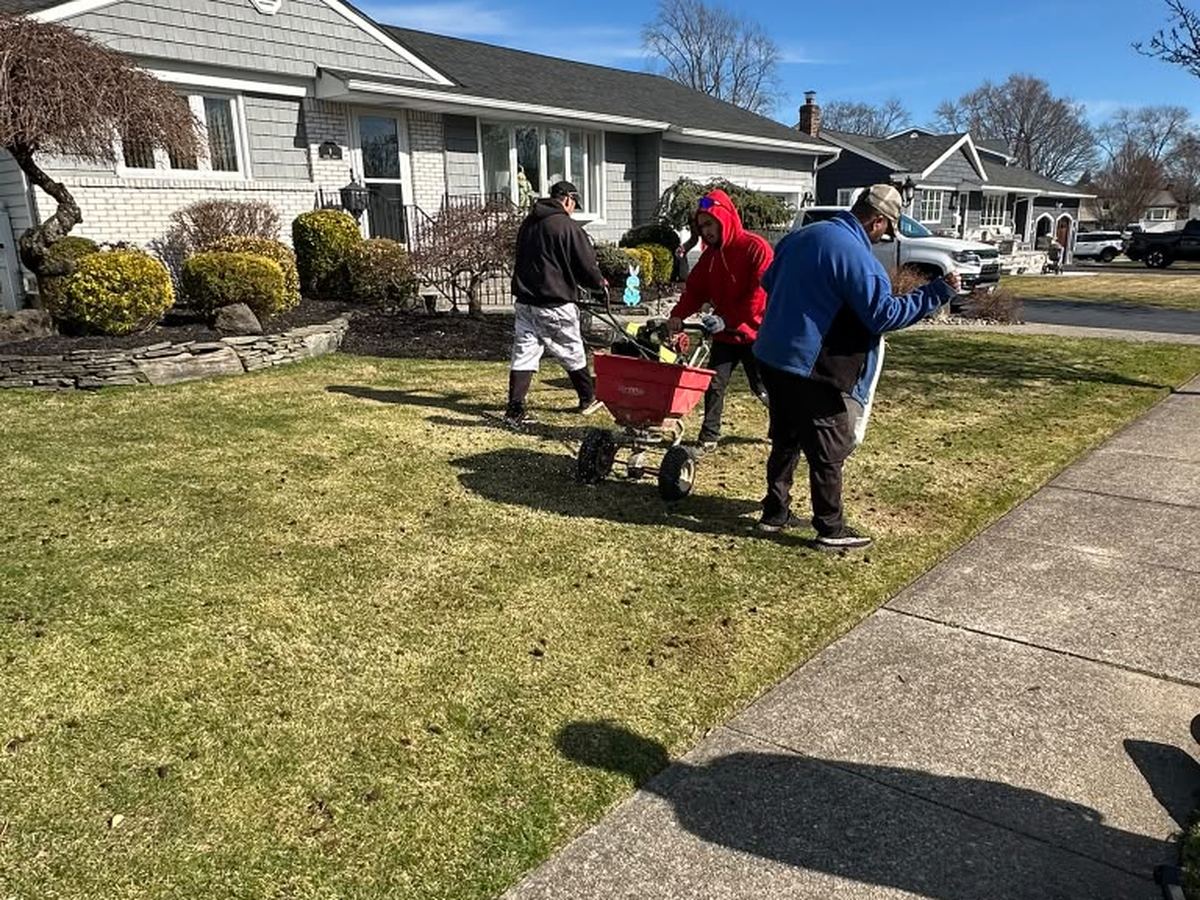 Crew loading debris into a wheelbarrow during a spring cleanup